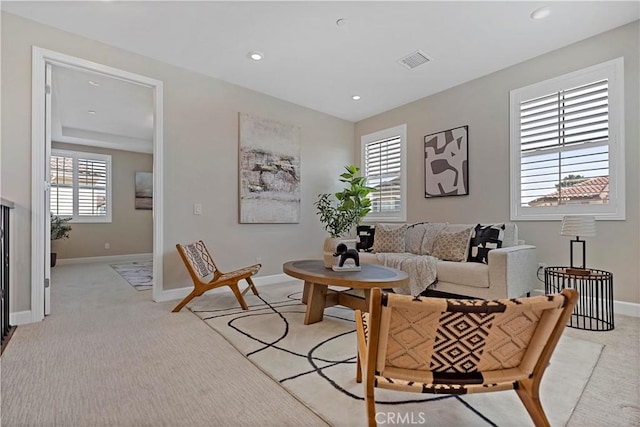 living room with recessed lighting, baseboards, visible vents, and light colored carpet