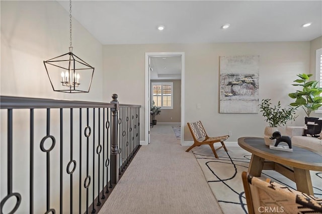 hall with recessed lighting, light colored carpet, a notable chandelier, and baseboards