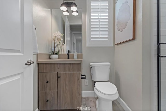 bathroom with toilet, tile patterned flooring, baseboards, and vanity