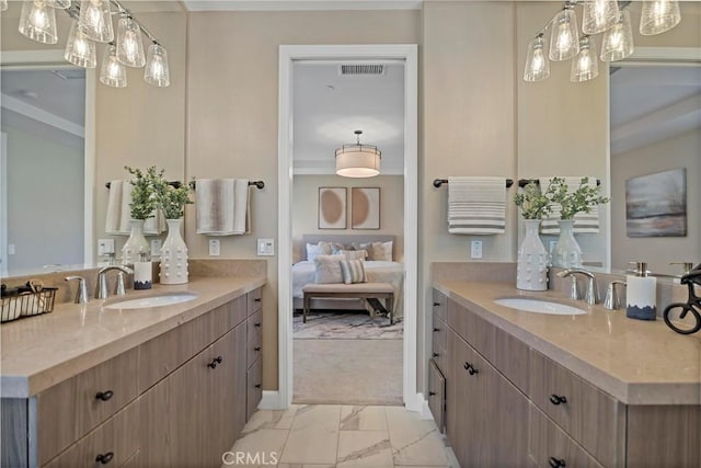 ensuite bathroom with two vanities, marble finish floor, visible vents, and a sink