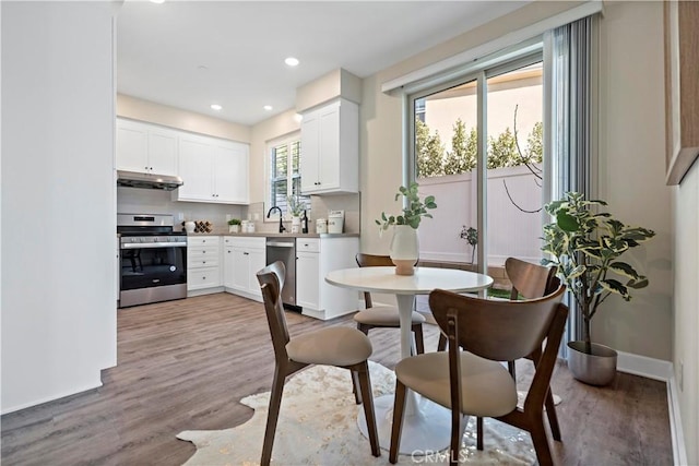 dining area featuring light wood-type flooring, baseboards, and recessed lighting