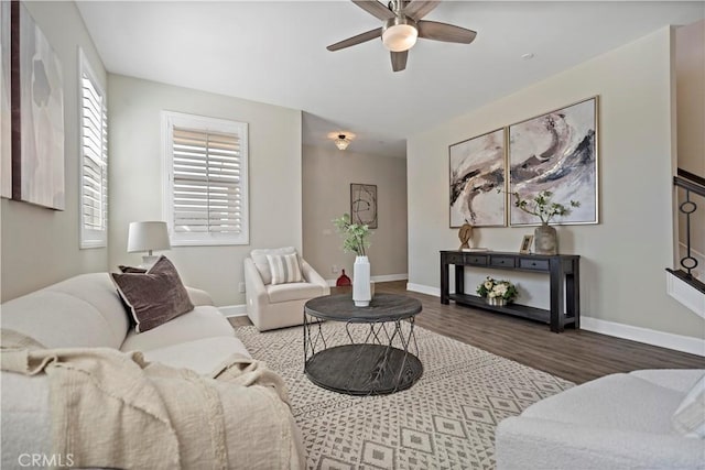 living room featuring wood finished floors, a ceiling fan, and baseboards