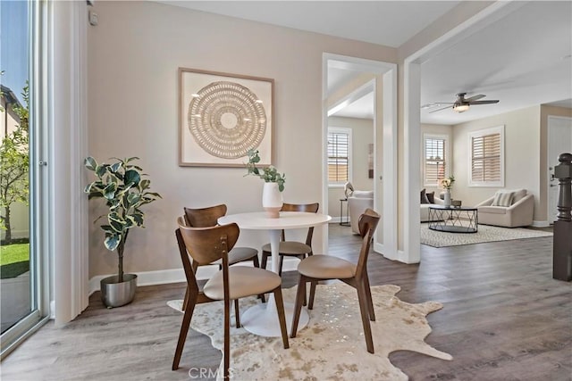 dining area featuring a ceiling fan, baseboards, and wood finished floors