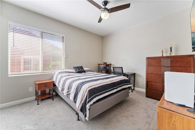 bedroom featuring light carpet, ceiling fan, and baseboards