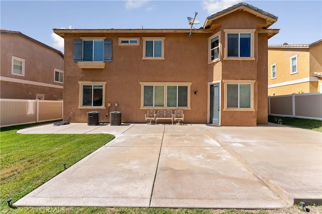 rear view of property featuring a patio, a yard, fence, and stucco siding