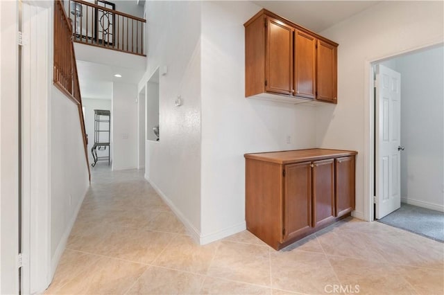 hall featuring recessed lighting, baseboards, and light tile patterned floors