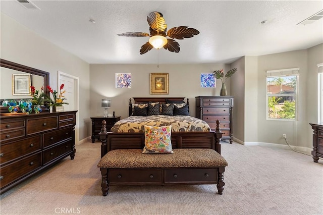 bedroom featuring light carpet, ceiling fan, visible vents, and baseboards