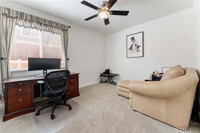 office area with a ceiling fan, light colored carpet, and baseboards