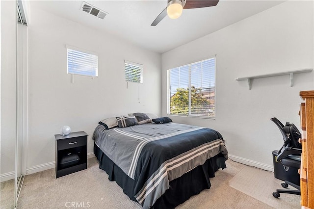 carpeted bedroom featuring baseboards, visible vents, and a ceiling fan