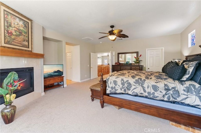 carpeted bedroom with a tile fireplace, ceiling fan, and baseboards