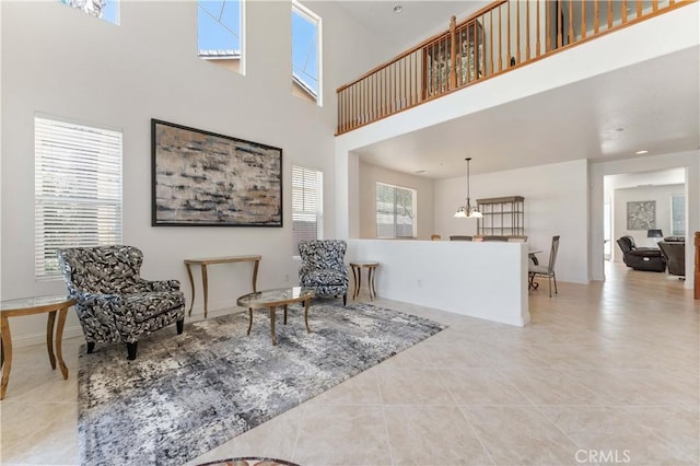 living area featuring a high ceiling and tile patterned floors