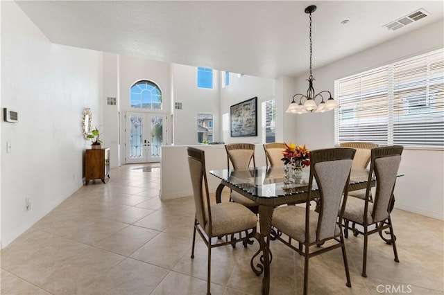 dining space with light tile patterned flooring, visible vents, baseboards, french doors, and an inviting chandelier