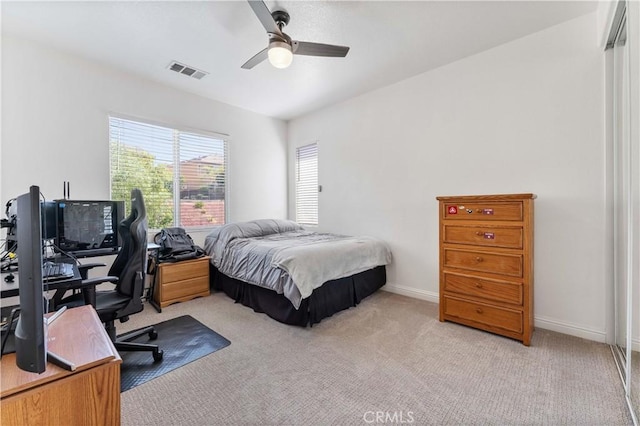 bedroom featuring light carpet, ceiling fan, visible vents, and baseboards