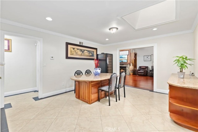 office area featuring ornamental molding, a lit fireplace, and baseboards