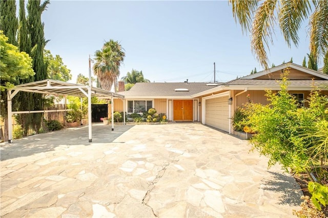 ranch-style house with a carport, driveway, an attached garage, and fence