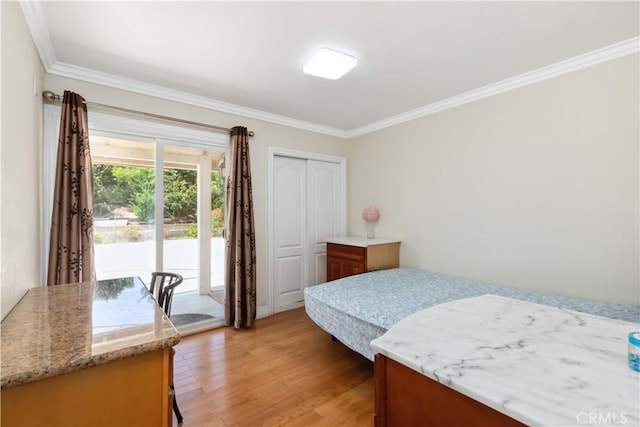 bedroom with access to exterior, a closet, ornamental molding, and light wood-style flooring