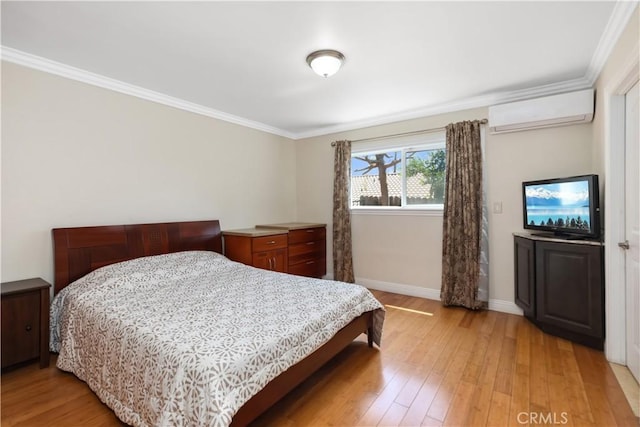 bedroom with light wood finished floors, crown molding, baseboards, and an AC wall unit