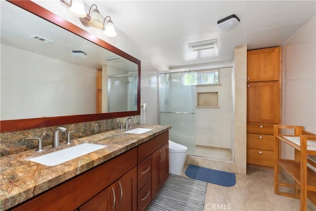 full bath featuring visible vents, a sink, a shower stall, and double vanity