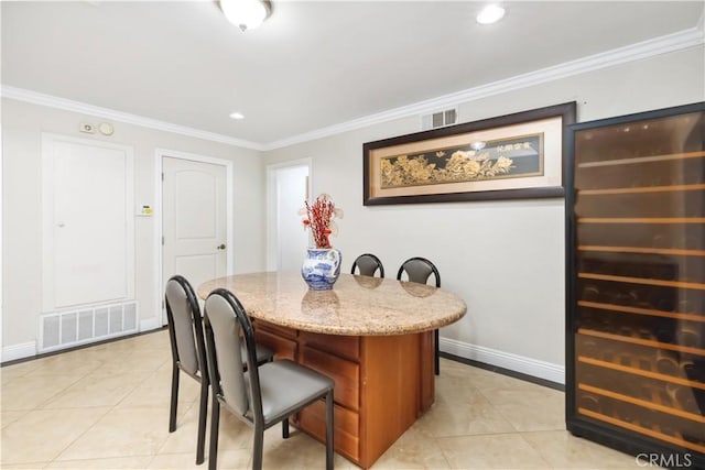 dining room with baseboards, visible vents, crown molding, and light tile patterned flooring