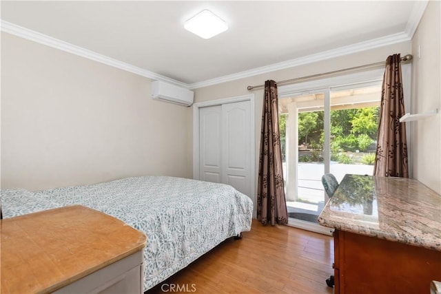 bedroom with ornamental molding, a closet, a wall unit AC, and light wood finished floors