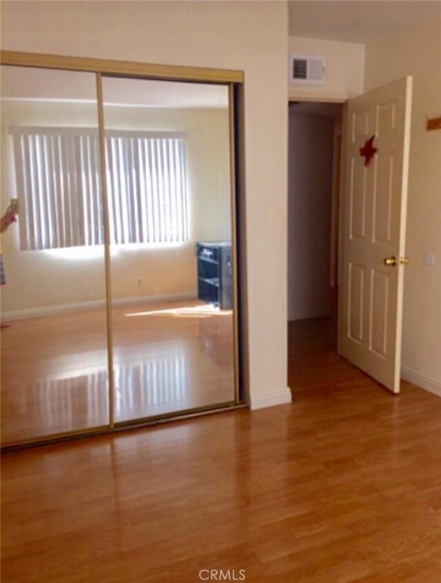 9146 Tobias Ave Unit 3, Panorama City, CA 91402 - unfurnished bedroom with wood finished floors, baseboards, and a closet