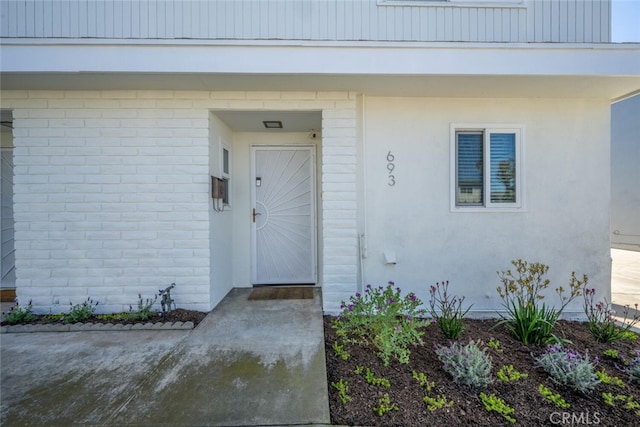 view of exterior entry featuring brick siding