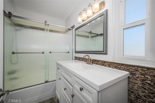 bathroom featuring combined bath / shower with glass door and vanity