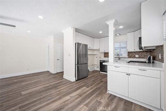 kitchen with a sink, black dishwasher, freestanding refrigerator, dark wood-style floors, and tasteful backsplash