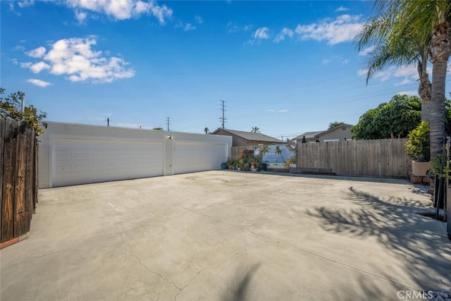 exterior space with a garage, an outbuilding, and fence