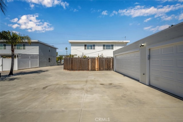 exterior space with a garage, fence, and stucco siding