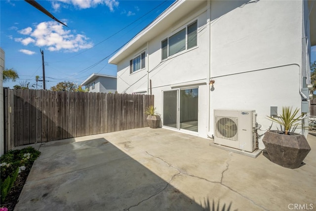 rear view of house with ac unit, a patio area, fence, and stucco siding