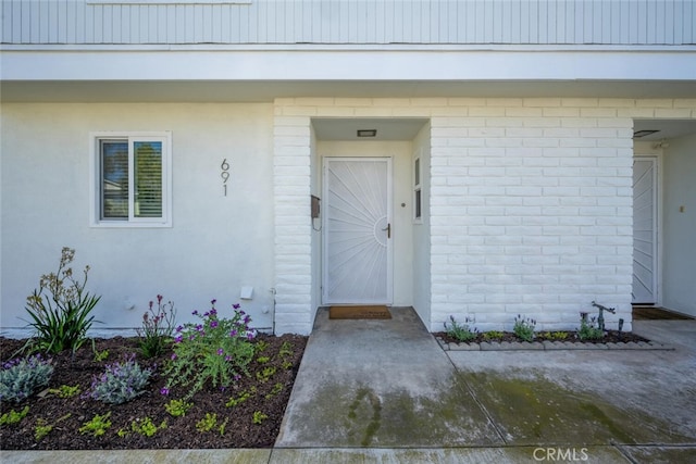 doorway to property with brick siding