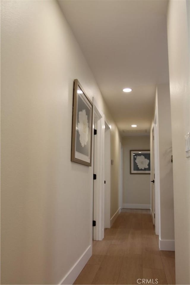 hall featuring recessed lighting, light wood-style flooring, and baseboards