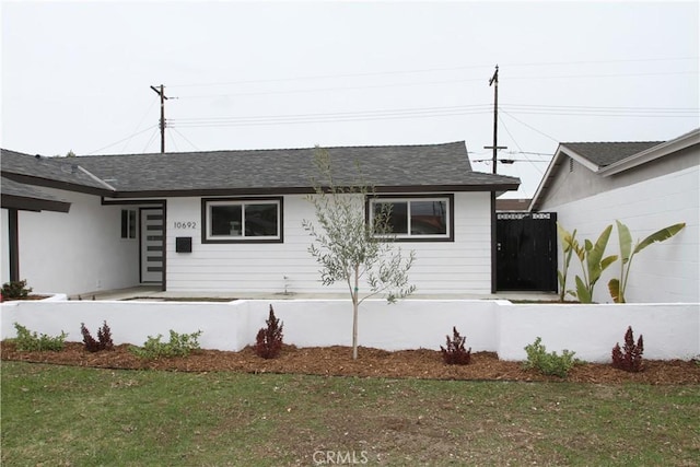 ranch-style home with a front lawn and a shingled roof