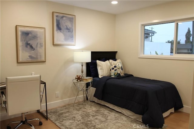 bedroom featuring baseboards, wood finished floors, and recessed lighting