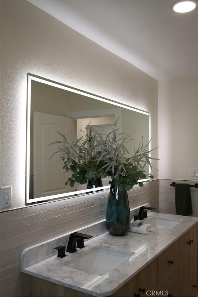 full bathroom with double vanity and a sink