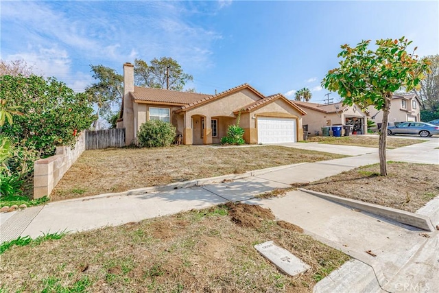 view of front of property with a garage, fence, concrete driveway, stucco siding, and a chimney