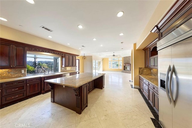 kitchen featuring visible vents, open floor plan, a center island, built in refrigerator, and recessed lighting