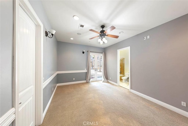 empty room featuring a ceiling fan, visible vents, baseboards, and carpet flooring