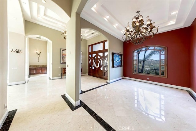 foyer entrance featuring a raised ceiling and baseboards