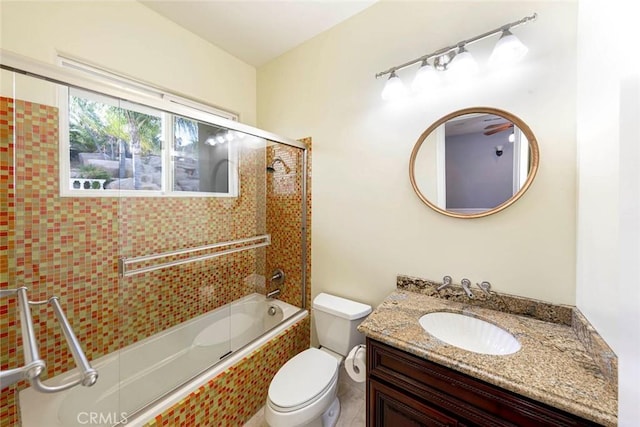 bathroom with combined bath / shower with glass door, vanity, and toilet