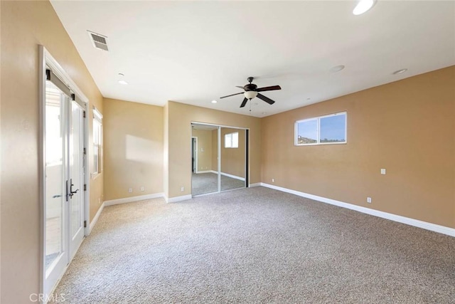 unfurnished bedroom with a closet, visible vents, light carpet, ceiling fan, and baseboards