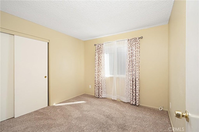 carpeted spare room featuring a textured ceiling