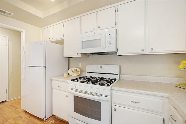kitchen with visible vents, white appliances, white cabinetry, and light countertops