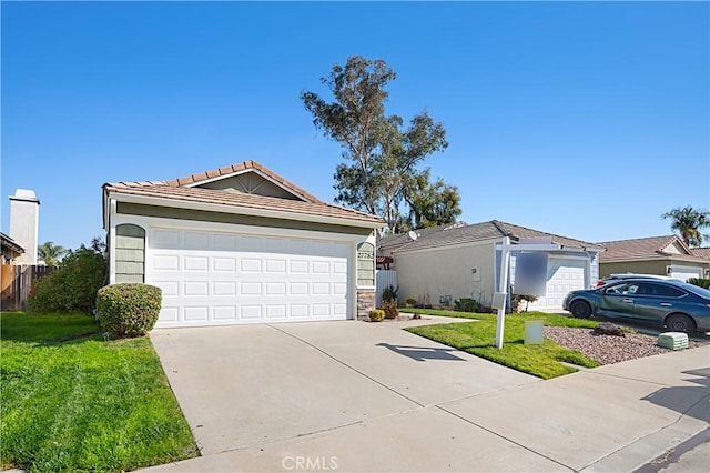 view of front of home featuring driveway, a front yard, and a tiled roof