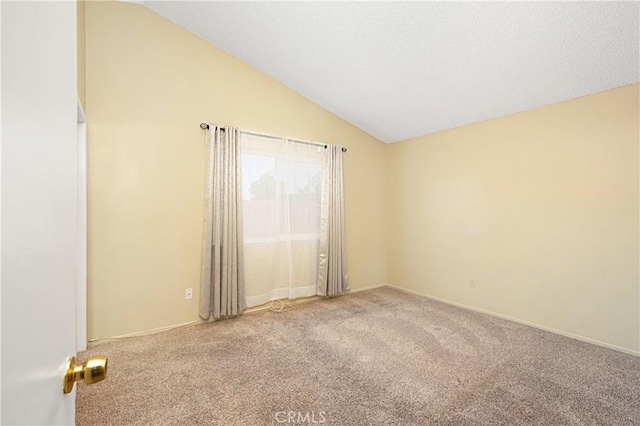 empty room with vaulted ceiling, carpet, and a textured ceiling
