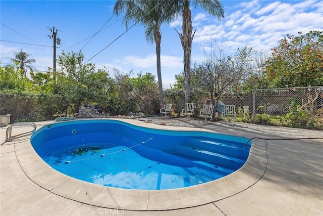 view of swimming pool with a patio area and fence