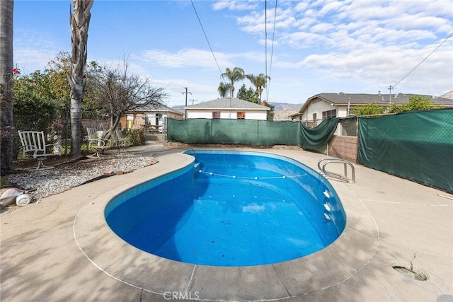 view of swimming pool featuring fence