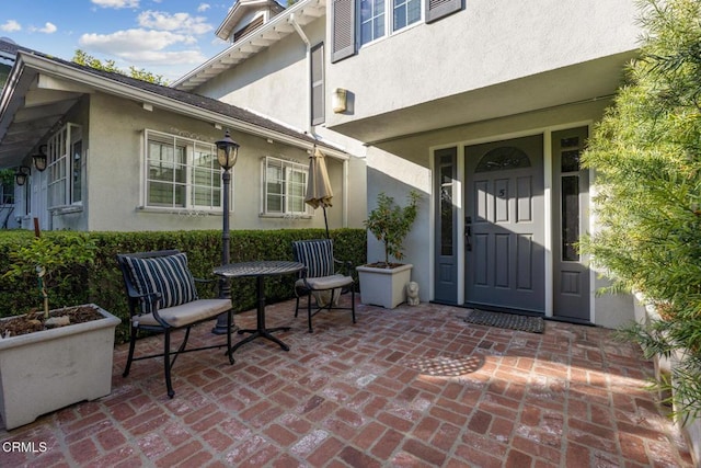 doorway to property featuring a patio area and stucco siding