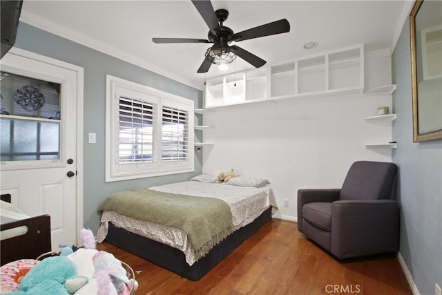 bedroom featuring wood finished floors, a ceiling fan, and baseboards